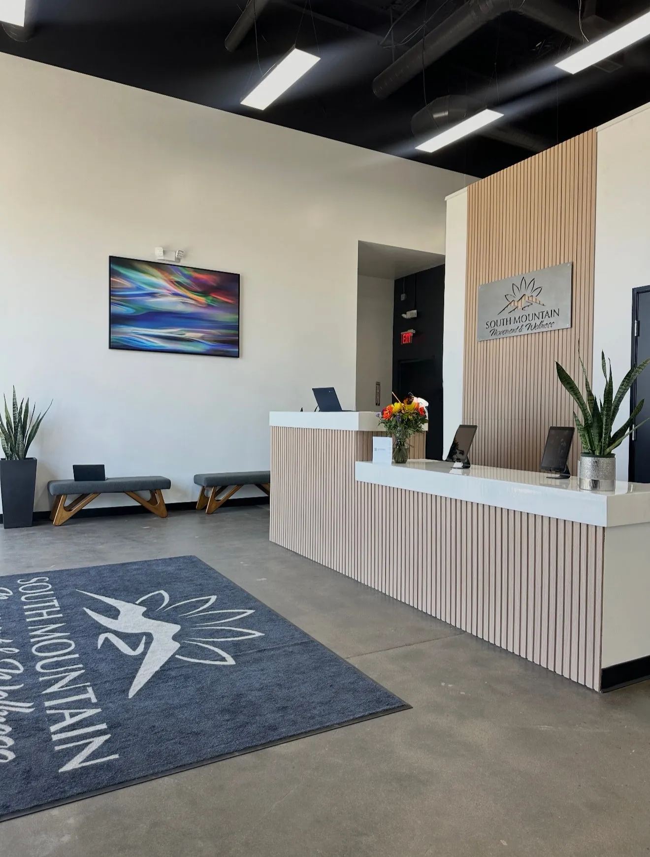 South Mountain BJJ front desk with wood slat wall, planters, and bench seating