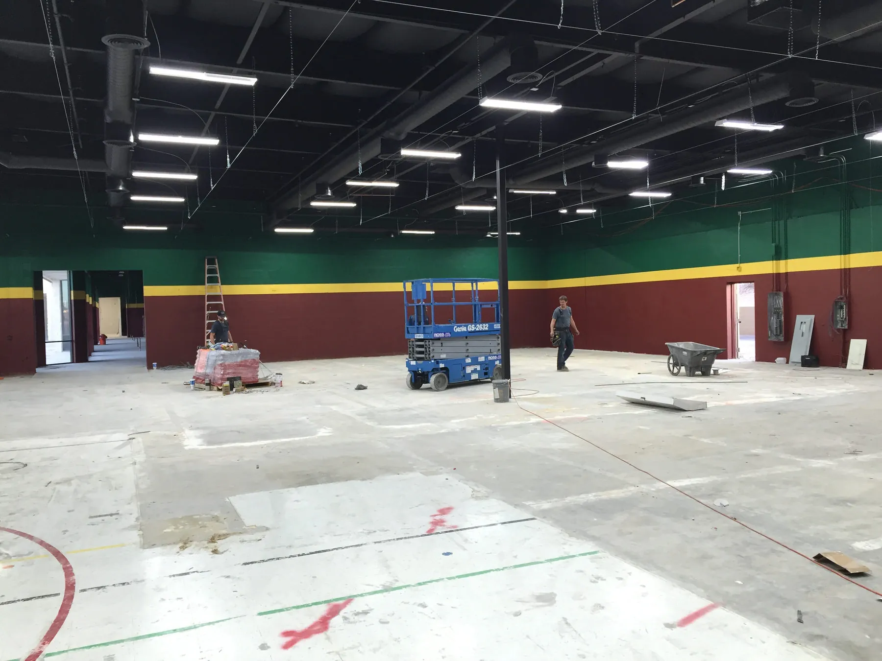 Large interior under construction with exposed ceiling structure and new lighting